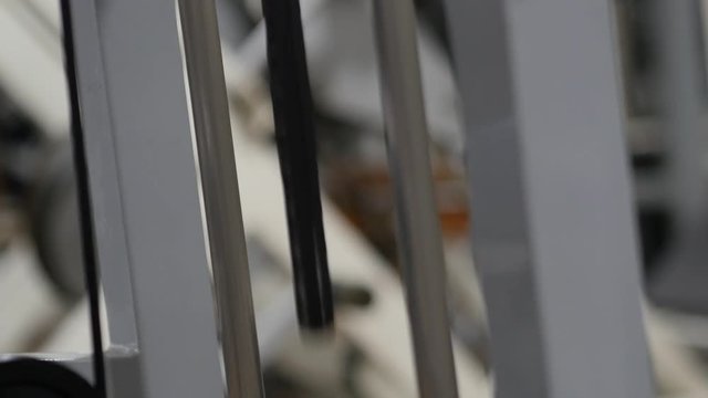 Close-up of the weighted plates on a exercise machine in motion at the gym