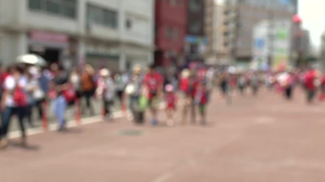 球場へ向かう赤いユニフォームを着た野球ファン、ぼかし
