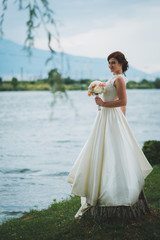 Fototapeta na wymiar Bride with bouquet at seaside