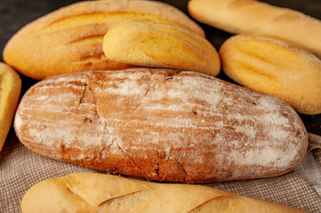 Various fresh bread and buns on a stone table. 