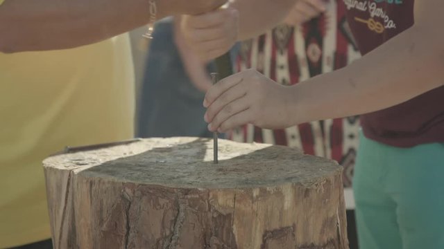 Nail game (jogo do prego) traditional portuguese game in summer village festivals with a wood trunk and a hammer