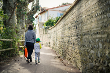 Fototapeta na wymiar Mère et son fils se promenant dans une ruelle