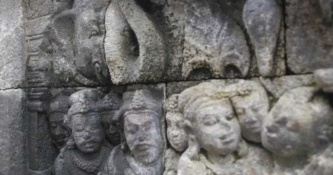 Panning close up shot of Borobudur ancient stone wall sculpture. Indonesia.