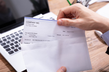 Businessperson Opening Envelope With Paycheck
