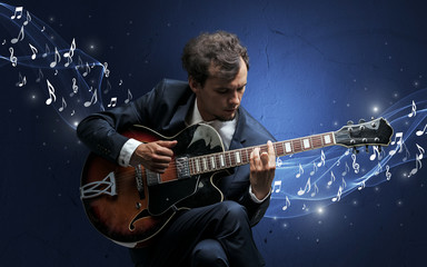Lonely musical composer with guitar and sparkling musical notes around