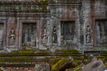 Fototapeta na wymiar Relief of apsaras and false windows with balusters in Ta Prohm temple, Cambodia