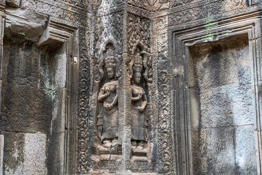 Relief of apsaras and false windows with balusters in Ta Prohm temple, Cambodia