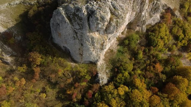 High angle aerial shot of rocky hill and landscape reveal