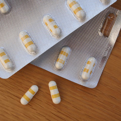 Pharmaceutical medicine capsules on wooden table. Pills in blister packaging