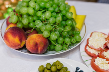 Fresh assorted fruit on a white plate.