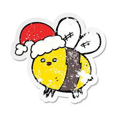 distressed sticker of a cute cartoon bee wearing christmas hat