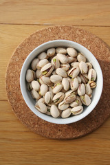 Pistachios in a bowl on wooden table 