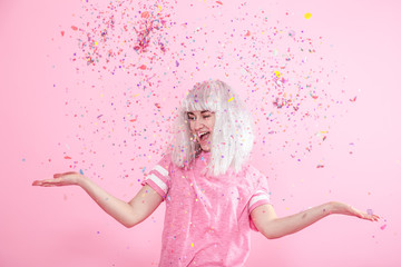 Funny Girl with silver hair gives a smile and emotion on pink background. Young woman or teen girl...