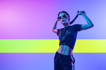 High Fashion model  woman in colorful bright neon uv blue and pink lights, posing in studio. Fashion concept and Zine culture