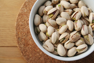 Pistachios in a bowl on wooden table 