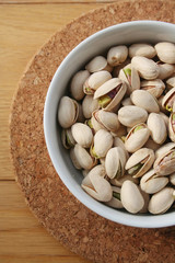 Pistachios in a bowl on wooden table 