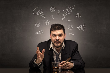 Young drunk man at his office with doodles around
