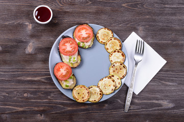 fried eggplant with sauce, tomato, onion and zucchini on a plate