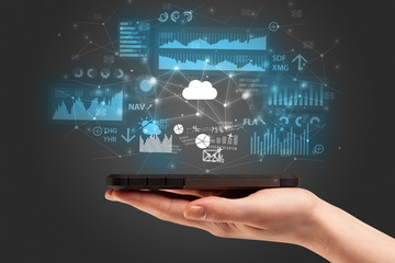 Businessman using phone with flying application icons around
