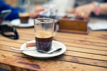 glass of coffee espresso macchiato on table in terrace cafe