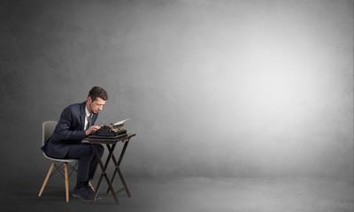 Man working hard on a typewriter in an empty space
