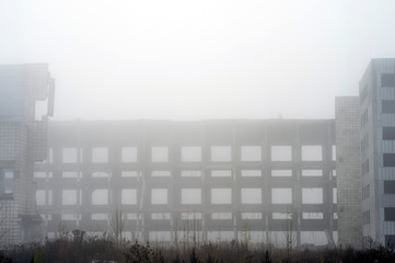 Frame of concrete piles of a large building in a thick foggy haze. The impact of the destruction. Background. Copy space