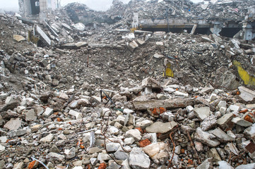 The remains of a large concrete building in the form of fragments of piles and piles of stones.