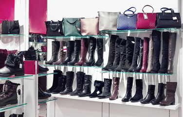 Shelves with beautiful  leather shoes and bags in store