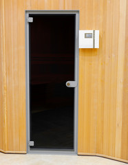 Entrance to traditional wooden Finnish sauna. Glass door indoor