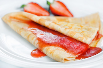 Thin delicious pancake with strawberry on white