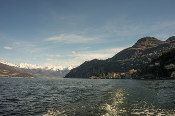 Fototapeta premium Italy, Bellagio, Lake Como, a large body of water with a snow alps in the background