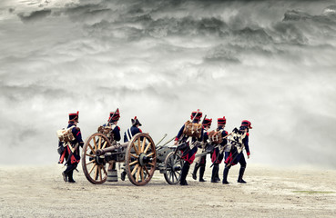 Napoleonic soldiers marching in open plain land with dramatic clouds., pulling a cannon.