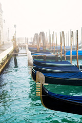 Fototapeta na wymiar Traditional gondolas in Venice during a misty/foggy spring day, Italy.
