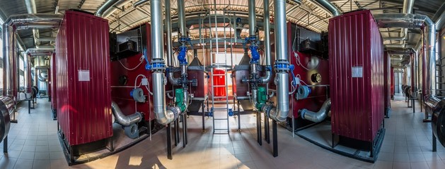 Wide-angle panoramic photo of the newest alternative fuel boiler room with pipes, towers and tanks, on a clear summer day, without people