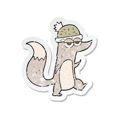 retro distressed sticker of a cartoon little wolf wearing hat