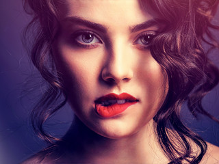 Fototapeta premium Face of a beautiful woman with a smoky eye makeup and red lipstick