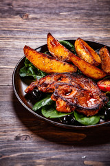 Grilled steak with potatoes and vegetables on wooden table