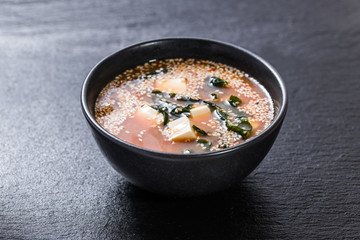 Miso tofu soup over slate plate background