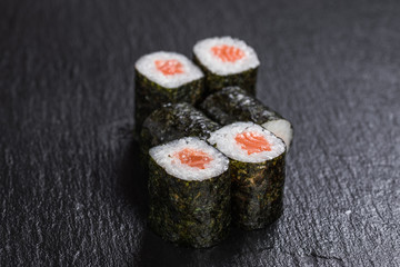 Maki with salmon on slate background