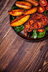 Grilled steak with potatoes and vegetables on wooden table