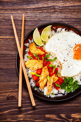 Grilled meat, white rice,fried egg vegetables on wooden table
