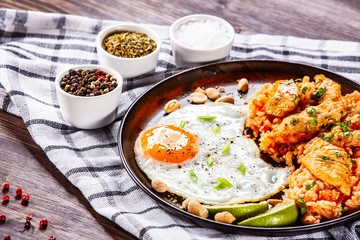 Grilled chicken meat with groats and fried egg on wooden table