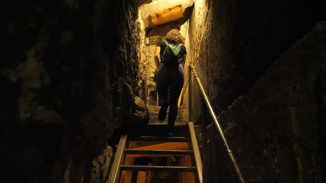 Young unrecognizable female tourist climbing stairs at Western Wall tunnels