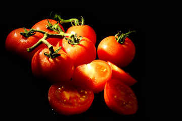 Fresh tomatoes on black background