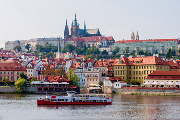 Obraz premium View of the old town and Prague Castle. The ship sails along the Vltava River in Prague, Czech Republic - August 28, 2018