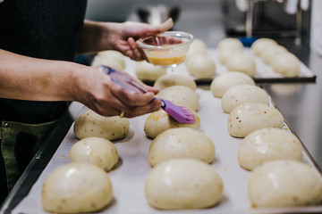 Bakery concept. Working woman preparing the dough before putting them to bake. Lifestyle.