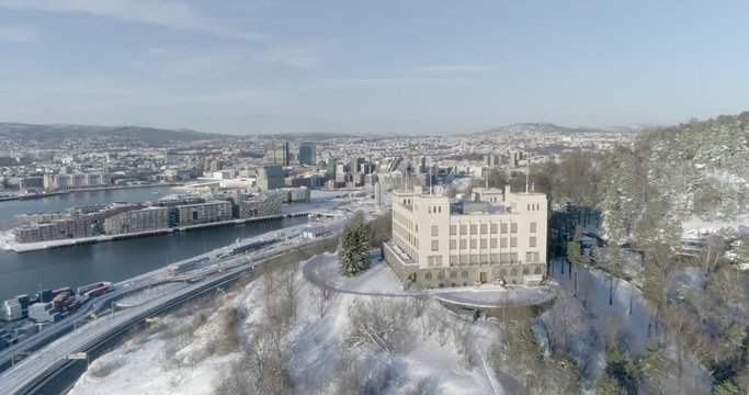 4K high angle aerial view of an old building used to train sailors with the Oslo skyline, The Munch Museum and the brand new Bj&oslash;rvika and Opera quarter, in the background.