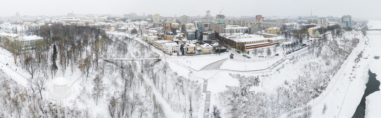 Obraz premium the city of Kirov and the high bank of the river Vyatka and the Alexander Grin Embankment and the rotunda on a cloudy winter day.