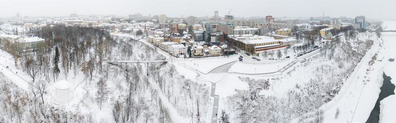 the city of Kirov and the high bank of the river Vyatka and the Alexander Grin Embankment and the rotunda on a cloudy winter day.