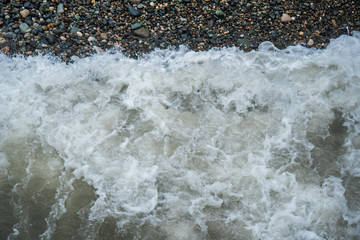 Top view of stone beach with small waves
